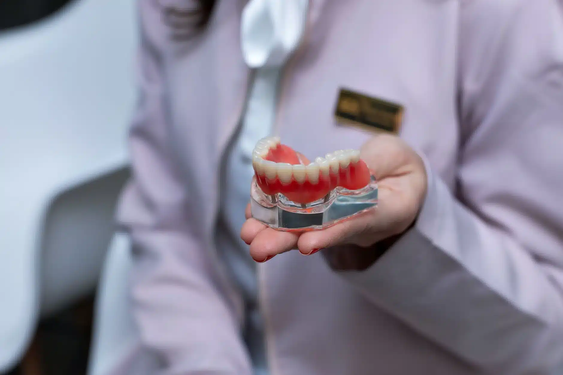 Dentiste montrant un modèle dentaire pour expliquer le changement d'appareil dentaire aux patients