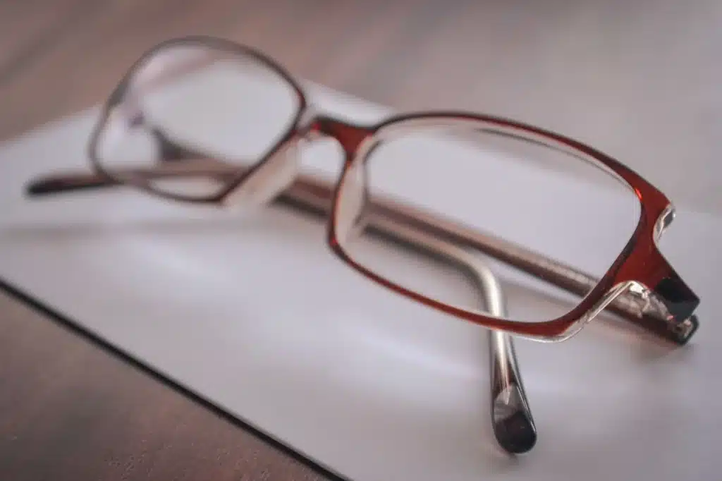 Élégantes lunettes mutualistes brunes posées sur du papier blanc